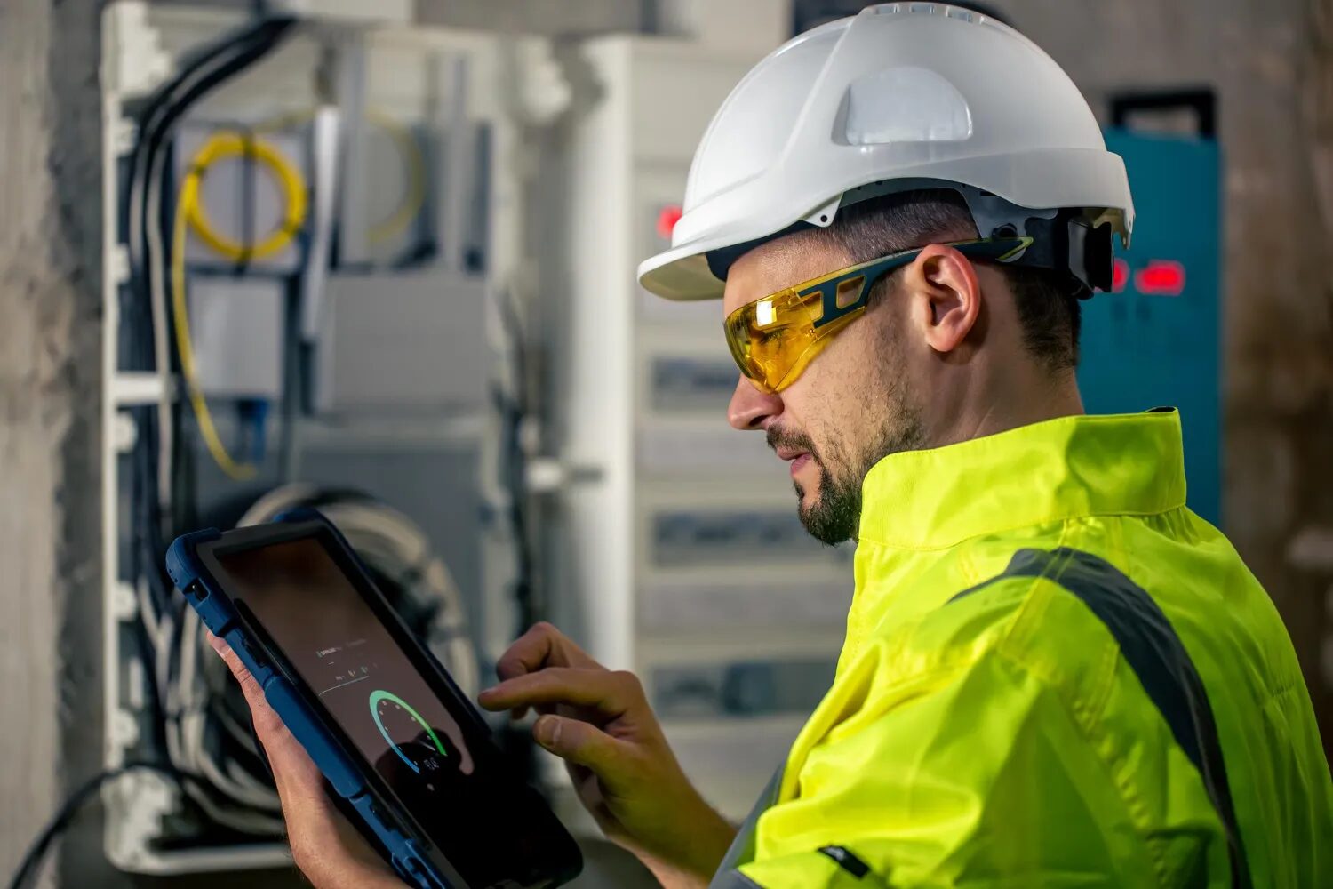 Worker in safety gear using a tablet for calibration services in Perth, Western Australia.